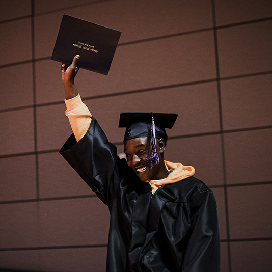  A student happily holds up his diploma